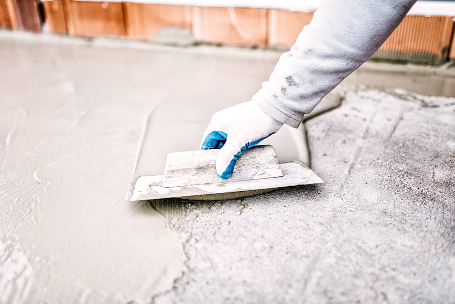 A Picture Of A Hand And A Concrete Trowel Smoothing Out Concrete Work. Adding A Layer Of Concrete To Create A New Smooth Service By Delaware County Concrete Services
